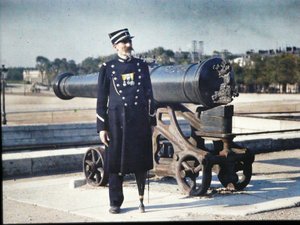 A Soldier in Uniform with Three Medals Standing Next to a Cannon in Paris, 1918